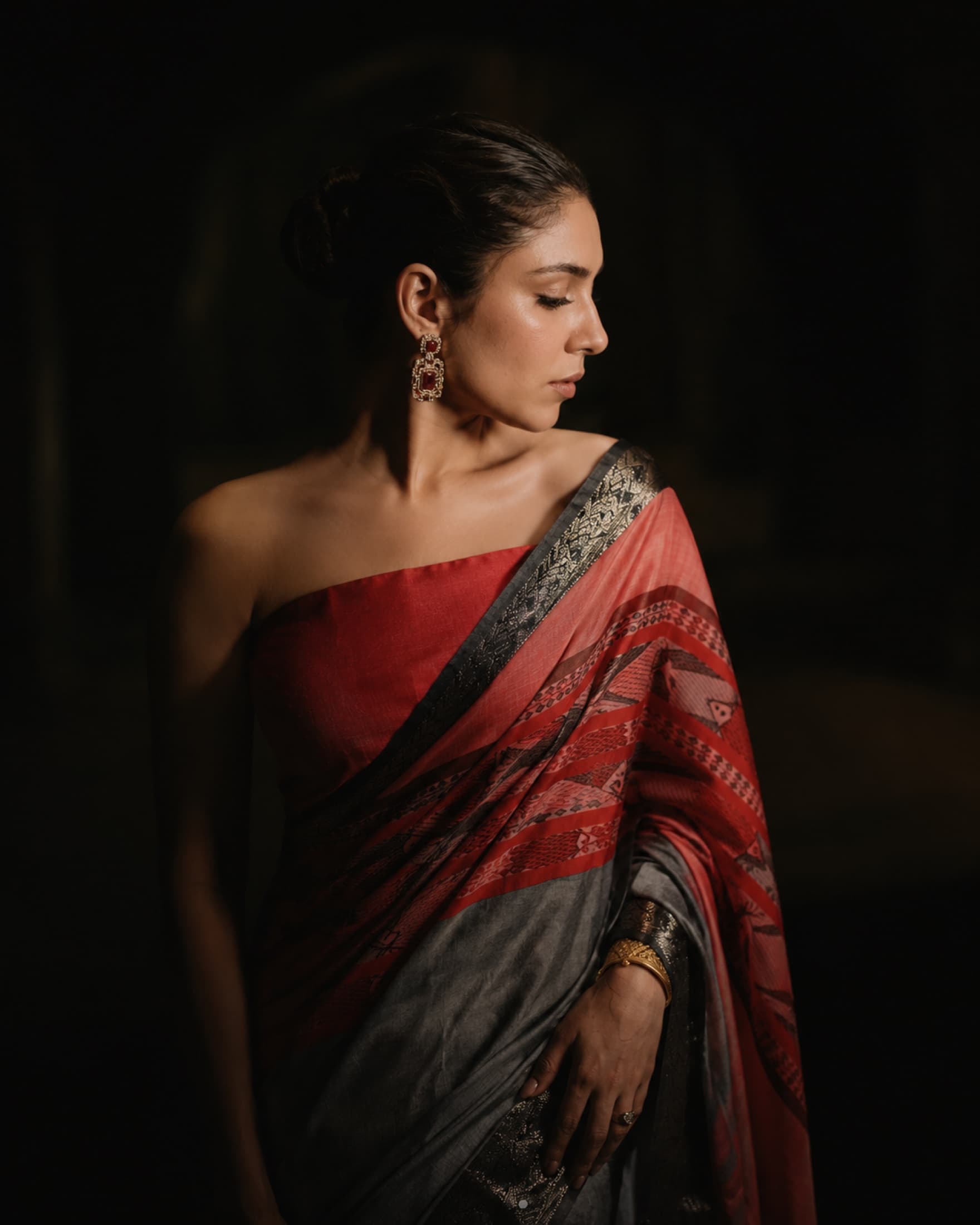Woman wearing a red blouse with a red and grey ANURRAKTI saree